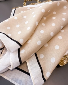 Close-up of beige polka dot silk scarf with herringbone weave in vintage tray