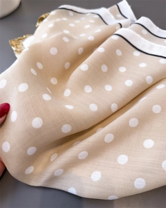 Macro shot of polka dot silk scarf featuring herringbone texture and contrast borders