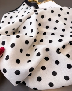 Detail of white scarf featuring black polka dots and high-quality twill weave texture
