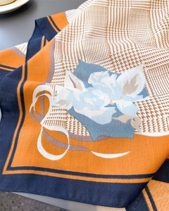 Gros plan détaillé du motif floral pied-de-poule sur un foulard carré en soie douce