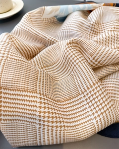 Gros plan d'un foulard en soie à motif pied-de-poule montrant la texture tricotée