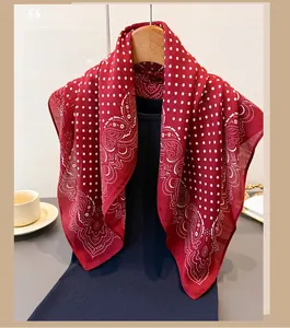 Detail of red scarf showing elegant white polka dots and paisley patterns on soft fabric