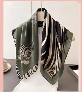 Close-up of olive green and zebra print silk-like scarf draped on a display stand