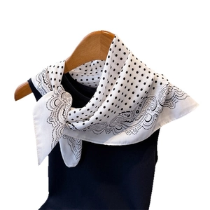 Square silk-feel scarf with black polka dots and paisley borders on wooden hanger