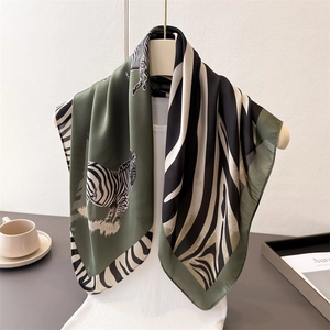 Elegant green silk scarf with contrast zebra print and deep green borders displayed vertically