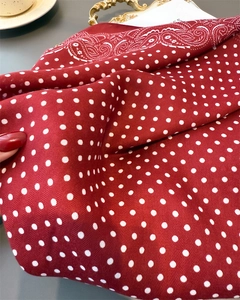 Macro shot of red polka dot silk scarf with white paisley print and twill texture fabric
