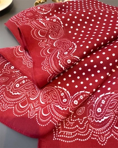 Close-up of red paisley and polka dot silk scarf showing twill texture and soft fabric