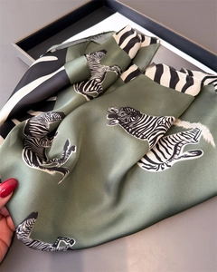 Detail of silk-like sage green scarf featuring elegant zebra print and smooth texture