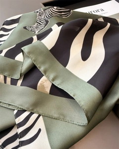Macro detail of silk scarf with contrast zebra print and olive green geometric patterns
