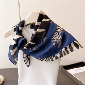 Blue silk-like scarf with zebra print and black and white striped border on white vest