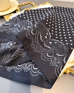 Detail of paisley and polka dot scarf showing herringbone texture on a golden tray