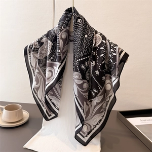 Élégant foulard en soie noir et blanc avec motif paisley et bordure géométrique