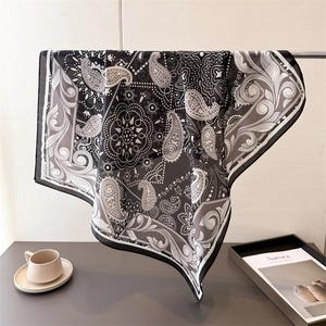 Élégant foulard en soie à motif cachemire noir et blanc drapé sur un support