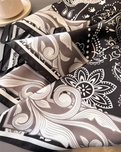 Détail d'un foulard en soie artificielle avec motifs paisley élégants noir et blanc