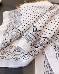 Close-up of white cotton-linen scarf featuring black paisley and polka dot patterns