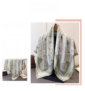 Detail of light green silk-like scarf featuring white camellia flowers and plaid border