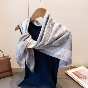 Floral silk-like satin scarf with vintage gray and white prints on a blue vest