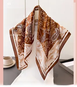 Macro view of paisley print silk scarf with vintage brown floral patterns on a white mannequin