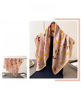 Detail of silk-like square scarf with floral print and fine yellow stitched edges