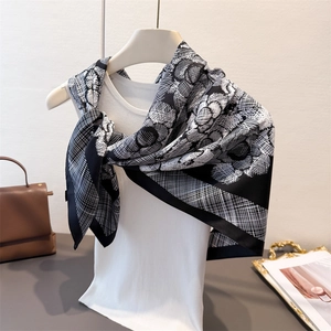 Elegant black and white floral silk square scarf draped on a mannequin for styling
