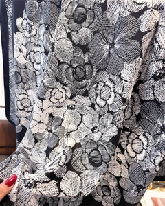 Detail shot of lightweight silk scarf with black camellia floral print and soft drape
