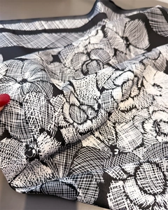 Detail of silk scarf showing vintage black and white floral print and fabric texture