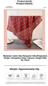 Detail of silk-like square scarf featuring red cherry print on dark brown satin fabric