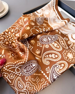 Detail of silk-like satin paisley square scarf showing glossy texture and rolled edges