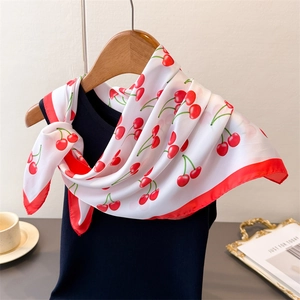 Elegant white silk scarf with red cherry print tied on a hanger for a stylish look