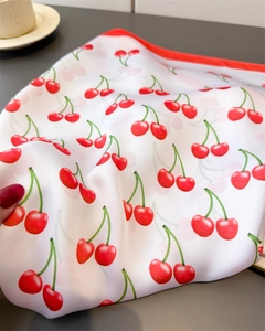 Detail of red cherry print on white silk square scarf with delicate red hemmed edges
