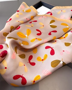 Detailed close-up showing the smooth silk texture and colorful paisley pattern of the scarf