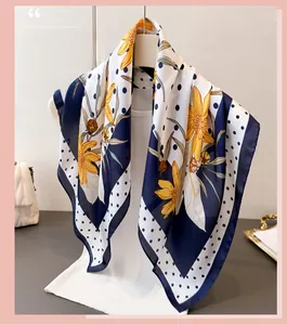 Detailed texture of navy blue silk scarf featuring white polka dots and yellow floral prints
