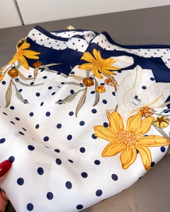 Detailed view of floral and polka dot print on premium faux silk neck scarf fabric