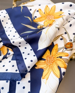 Detail of silk-like scarf featuring sunflower prints with navy stripes and polka dots