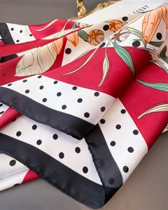 Detail of red floral silk scarf with polka dots, smooth texture and black piping