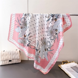 Detail of floral and polka dot silk-like square scarf draped with elegant draping