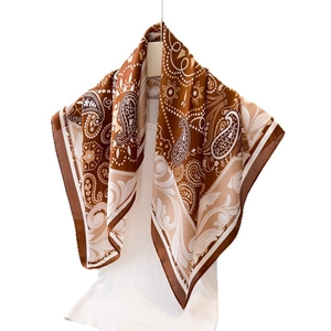 Brown and beige paisley print silk satin square scarf displayed on a white mannequin