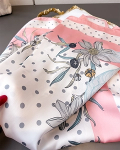 Detailed view of floral silk scarf featuring grey polka dots and soft pink hand-painted flowers