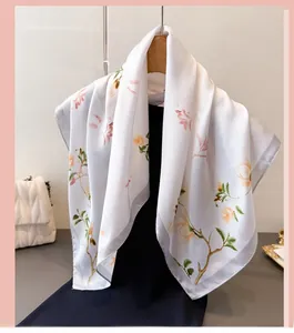 Détail d'un foulard en soie avec motif floral élégant sur un fond blanc soyeux