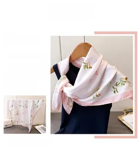 Détail d'un foulard en soie à imprimé floral avec bords roulés roses et cerises