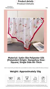 Détail d'un élégant foulard en satin de soie à imprimé floral et bordure rouge