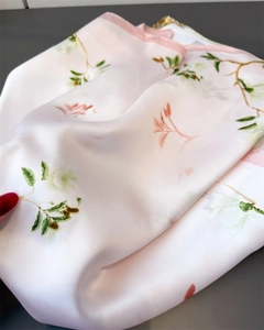 Détail de l'imprimé fleur de magnolia sur tissu satiné de foulard en soie rose doux