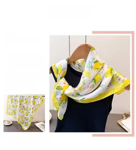 Detailed view of the yellow hand-rolled edge on a silk lemon print square scarf