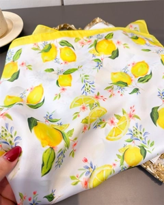 Detail showing the lemon print pattern and delicate yellow stitching on the silk scarf