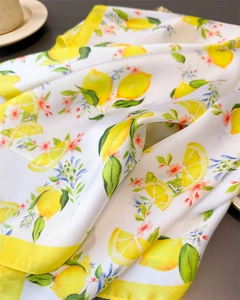 Detailed close-up of silk-like lemon print scarf showing vibrant citrus patterns and texture