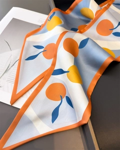 Detailed shot of silk scarf with orange fruit patterns and high-quality stitched edges