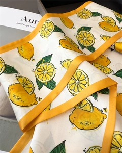 Detailed close-up of vibrant lemon print silk scarf with yellow satin borders