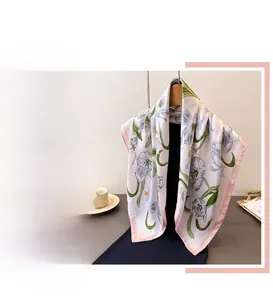 Detail of elegant white silk scarf featuring hand-painted tulip floral prints and pink edges