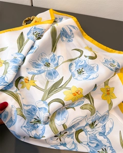 Detailed macro view of blue tulip print and yellow hem on faux silk square scarf