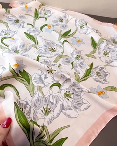 Detailed view of floral silk scarf featuring elegant tulip patterns and soft fabric drapes
